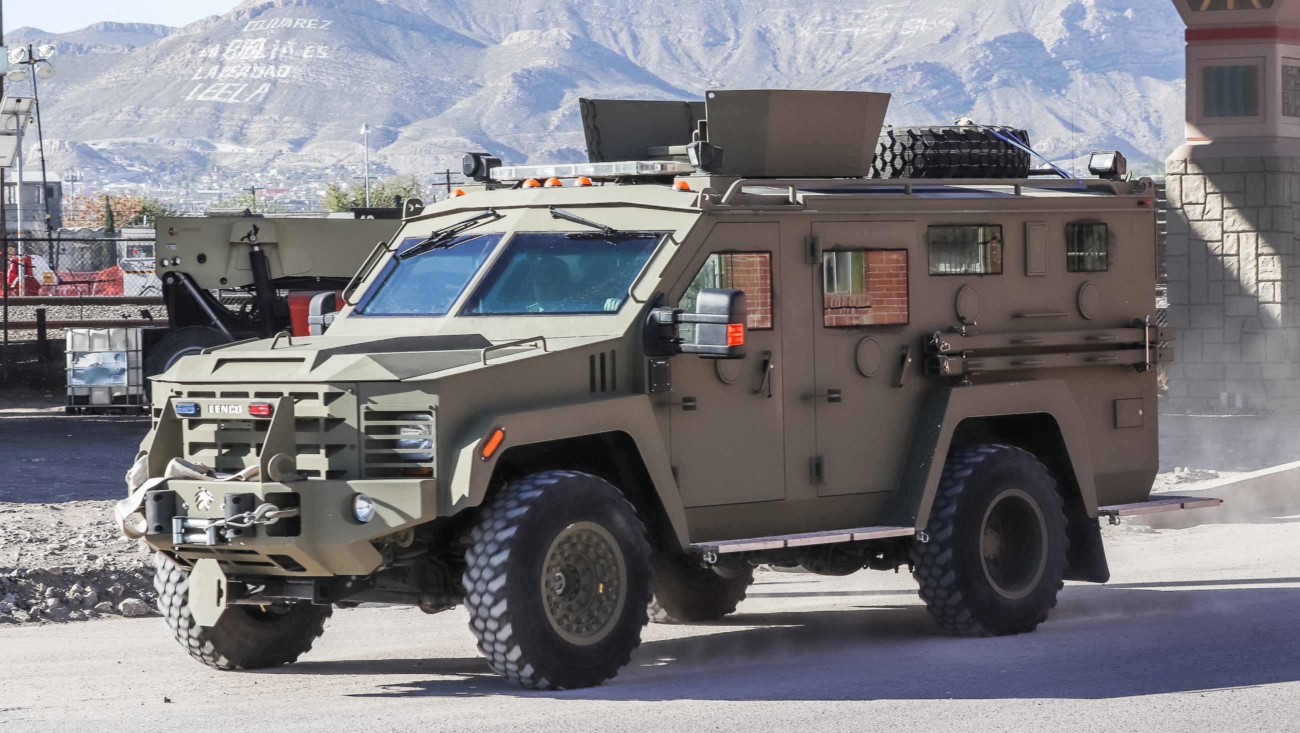 An armored personnel carrier with a roof-mounted turret shield, representative of the vehicle class studied in this paper.